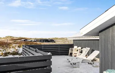 a deck with white chairs on a house at Gorgeous Home In Thisted With Sauna in Thisted