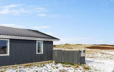 a black house with a fence in the snow at Gorgeous Home In Thisted With Sauna in Thisted