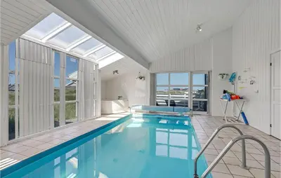 a swimming pool in a house with a large window at Stunning Home In Thisted With Sauna in Klitmøller