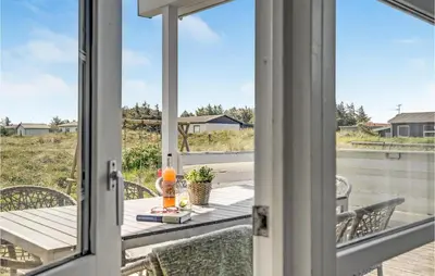 a dining room with a table and chairs on a balcony at Stunning Home In Thisted With Sauna in Klitmøller