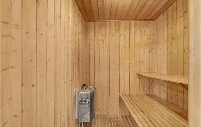a sauna with a heater in a wooden wall at Stunning Home In Thisted With Sauna in Klitmøller