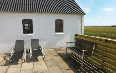 three chairs and a bench in front of a building at Holiday Home Glombak in Vesløs