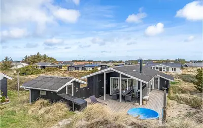 a house on the beach with a wooden deck at Holiday Home Johnsvej Thisted V in Thisted