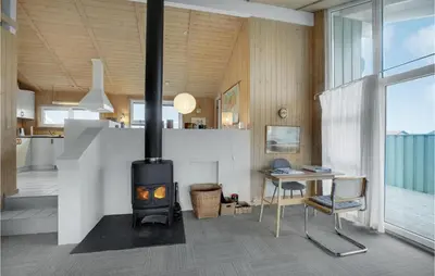 a fireplace in a living room with a desk and a table at Holiday Home Kløvborgsti Thisted Ix in Thisted