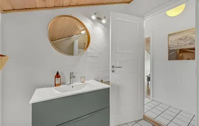 a white bathroom with a sink and a mirror at Amazing Home In Thisted With Sauna in Thisted