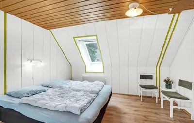 a bedroom with a large bed in a white room at Rishøj in Løgstrup