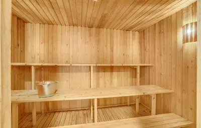 a sauna with a bench and a bucket in it at Rishøj in Løgstrup