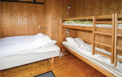 two bunk beds in a room with wooden walls at Holiday Home Fjordparken Farsø Iv in Farsø