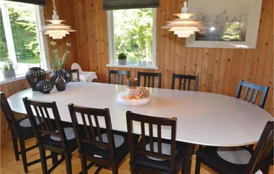 a dining room with a large white table and chairs at Holiday Home Fjordparken Farsø Iv in Farsø