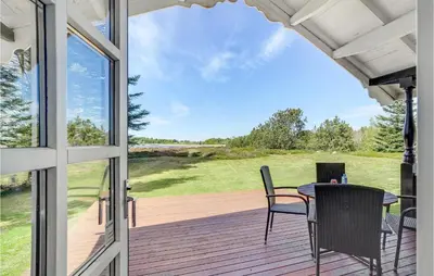 a patio with a table and chairs on a deck at Holiday Home Venøvej Højslev Denm in Højslev