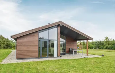 a small house with glass doors on a lawn at Holiday Home Bronzehøjen Højslev in Højslev