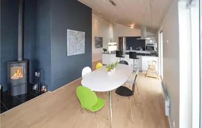 a dining room with a white table and green chairs at Holiday Home Bronzehøjen Højslev in Højslev