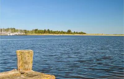 a wooden post in the middle of a body of water at Holiday Home Bronzehøjen Højslev in Højslev