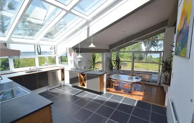 a kitchen with a glass ceiling with a table and chairs at Holiday Home Hesselvej in Farsø