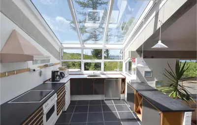 an attic kitchen with a large skylight at Holiday Home Hesselvej in Farsø
