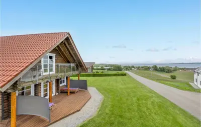 a house with a deck and a view of the ocean at Holiday Home Husvej in Fur