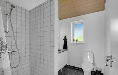 a bathroom with a shower and a toilet and a window at Holiday Home Marthasvej in Løgstør