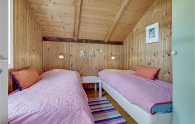 two beds in a room with wooden walls at Holiday Home Agathesvej Løgstør V in Løgstør