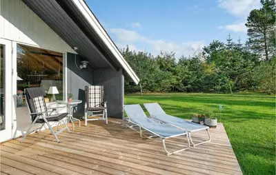 a deck with two chairs and a table and a table at Holiday Home Agathesvej Løgstør V in Løgstør