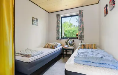 a bedroom with two beds and a window at Holiday Home Bjarkesvej in Farsø