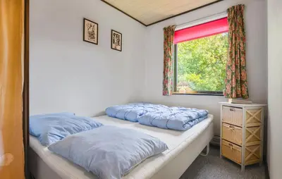 two beds in a room with a window at Holiday Home Bjarkesvej in Farsø