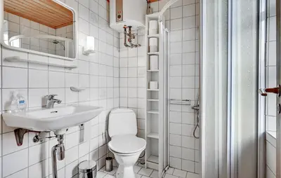 a small bathroom with a toilet and a sink at Holiday Home Eskovvej in Roslev