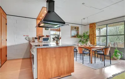 a kitchen with a table and a stove top oven at Holiday Home Eskovvej in Roslev