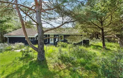 a house in the middle of a field with trees at Holiday Home Revlingestien Fjerritslev V in Fjerritslev