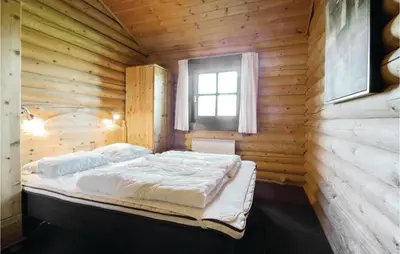 a bed in a wooden room with a window at Holiday Home Lyngbjergvej Vi in Fjerritslev