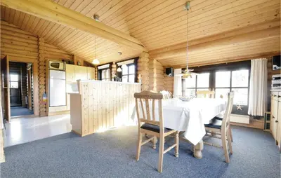 a dining room with a white table and chairs at Holiday Home Lyngbjergvej Vi in Fjerritslev