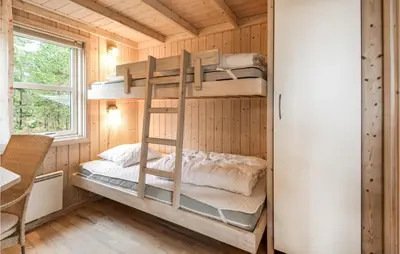 a bedroom with bunk beds in a tiny house at Holiday Home Revlingestien Fjerritslev Iv in Fjerritslev