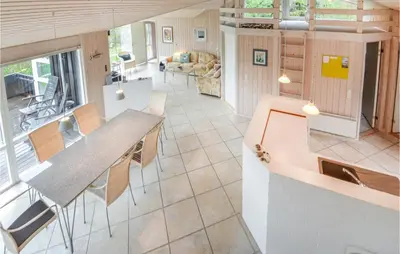 an open kitchen and living room with a table and chairs at Holiday Home Revlingestien Fjerritslev Iv in Fjerritslev