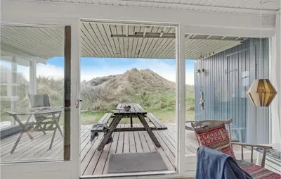 a screened in porch with a table and a desk at Holiday Home Svenstibakkevej Denm in Frøstrup