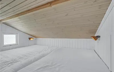 a white bed in a white room with a window at Holiday Home Svenstibakkevej Denm in Frøstrup