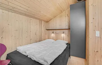 a bed in a room with a wooden ceiling at Holiday Home Svenstibakkevej Denmark I in Frøstrup