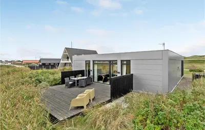 a house on top of a hill with a deck at Holiday Home Hjelmevej Ulfborg Vi in Ulfborg