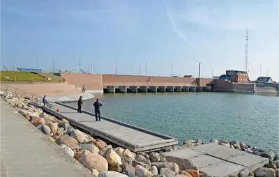 two people standing on a dock near the water at Holiday Home Hjelmevej Ulfborg Vi in Ulfborg