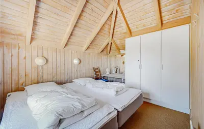 a bedroom with a large bed in a wooden room at Holiday Home Tulipanvej Fjerritslev I in Fjerritslev