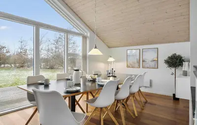 a dining room with a table and chairs at Holiday Home Kronvildtvej Brovst Vi in Brovst