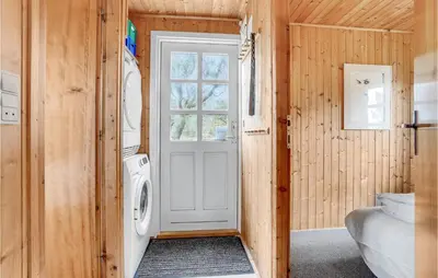 a laundry room with a washer and dryer and a door at Holiday Home Svenstibakkevej Denmark Ii in Frøstrup