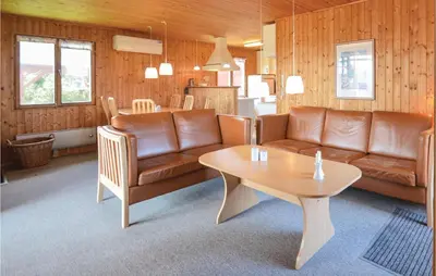 a living room with a couch and a table at Holiday Home Svenstibakkevej Frøstrup Iv in Frøstrup