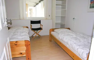 two beds in a room with a chair and a window at Gorgeous Home In Frøstrup With Wifi in Frøstrup