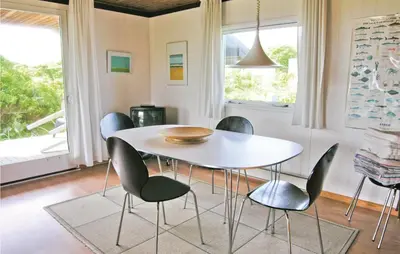 a dining room with a white table and chairs at Holiday Home Svenstibakkevej Frøstrup Xii in Frøstrup