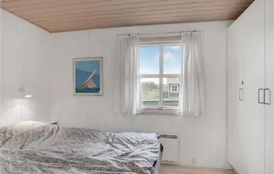 a bedroom with a bed and a window at Holiday Home Svenstibakkevej Denmark in Frøstrup