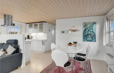 a kitchen and living room with a table and chairs at Holiday Home Svenstibakkevej Denmark in Frøstrup