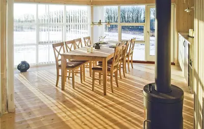 a dining room with a wooden table and chairs at Holiday Home Aspevej Fjerritslev Xi in Fjerritslev
