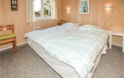 a large bed in a bedroom with a window at Jydehuset in Fjerritslev