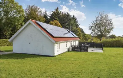 a small white building with a red roof in a field at Holiday Home Strandvejen Brovst Denm in Brovst
