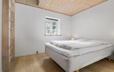 a bedroom with a bed with a wooden ceiling at Holiday Home Strandvejen Brovst Denm in Brovst