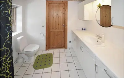a bathroom with a toilet and a sink and a mirror at Holiday Home Strandvejen Brovst Denm in Brovst